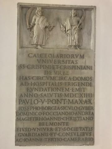 Lapide raffigurante i santi Crispino e Crispiniano recante iscrizione latina in lettere capitali, 1614